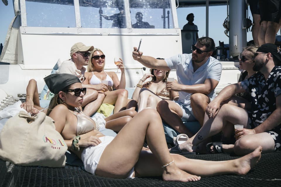 Lisbon: Catamaran Boat Party with Music, Open Bar & Dives - Water time: cooling off with an easy ladder (and why a towel matters)
